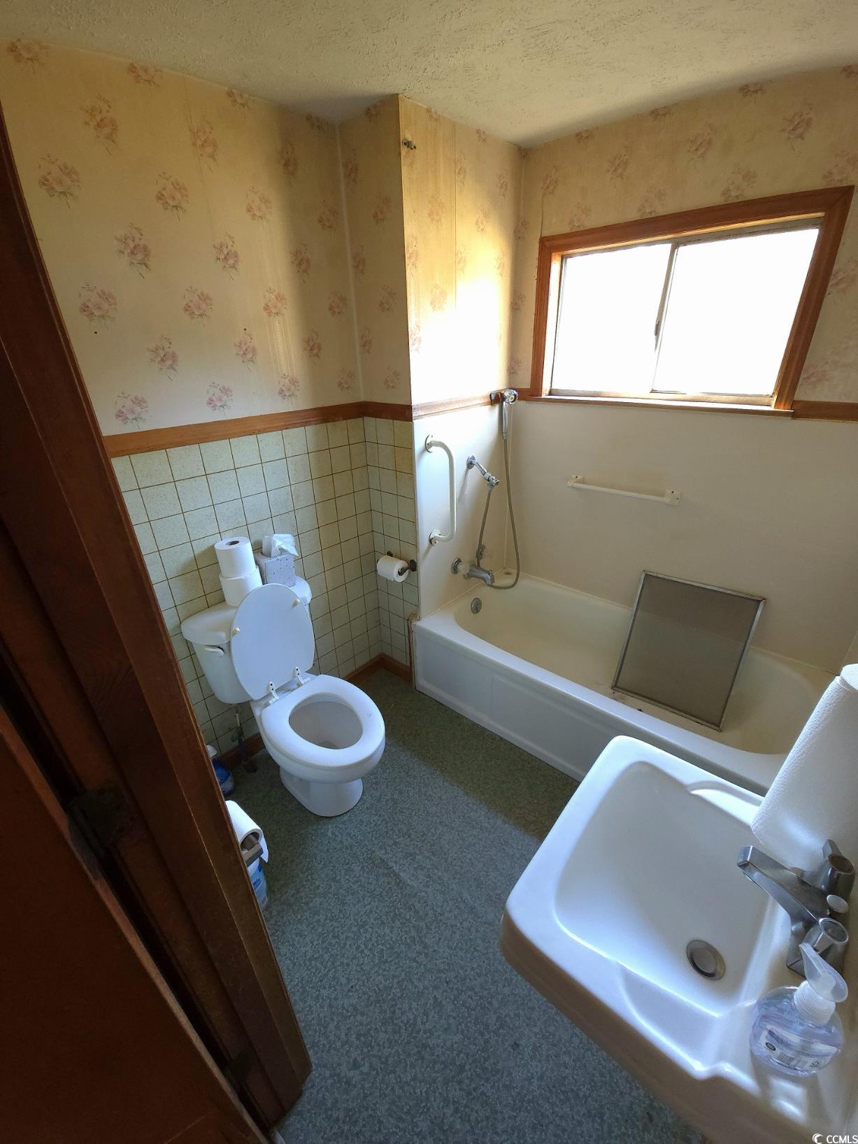150 Landmark Road Conway, SC 29527 - Photo 15 of 35 Bathroom with wallpapered walls, wainscoting, a textured ceiling, and tile walls