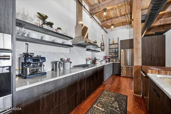 a kitchen with stainless steel appliances granite countertop a sink a stove and a refrigerator