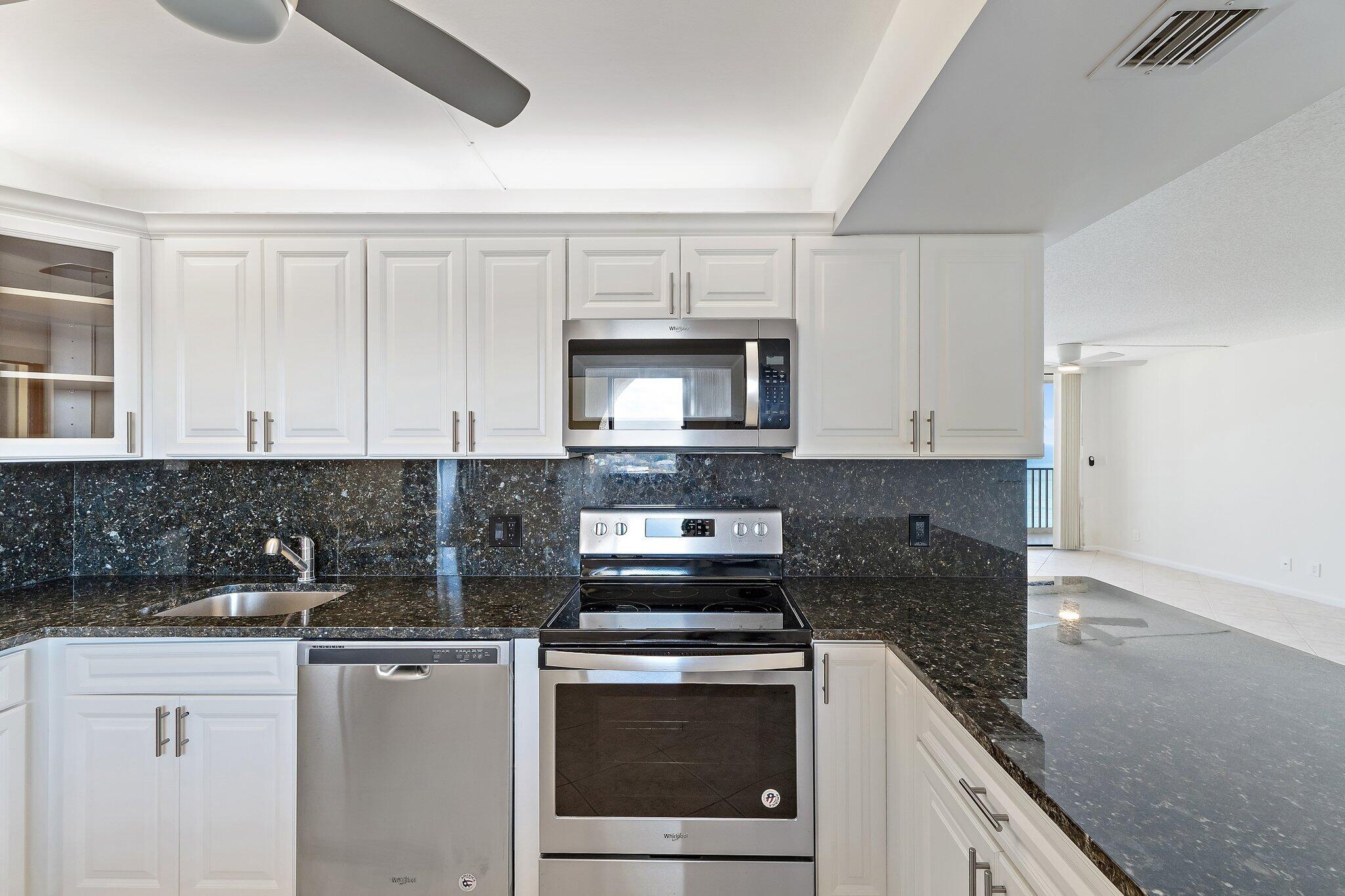 300 Ocean Trail Way, Unit 1406 Jupiter, FL 33477 - Photo 15 of 42 a kitchen with a sink stove and microwave