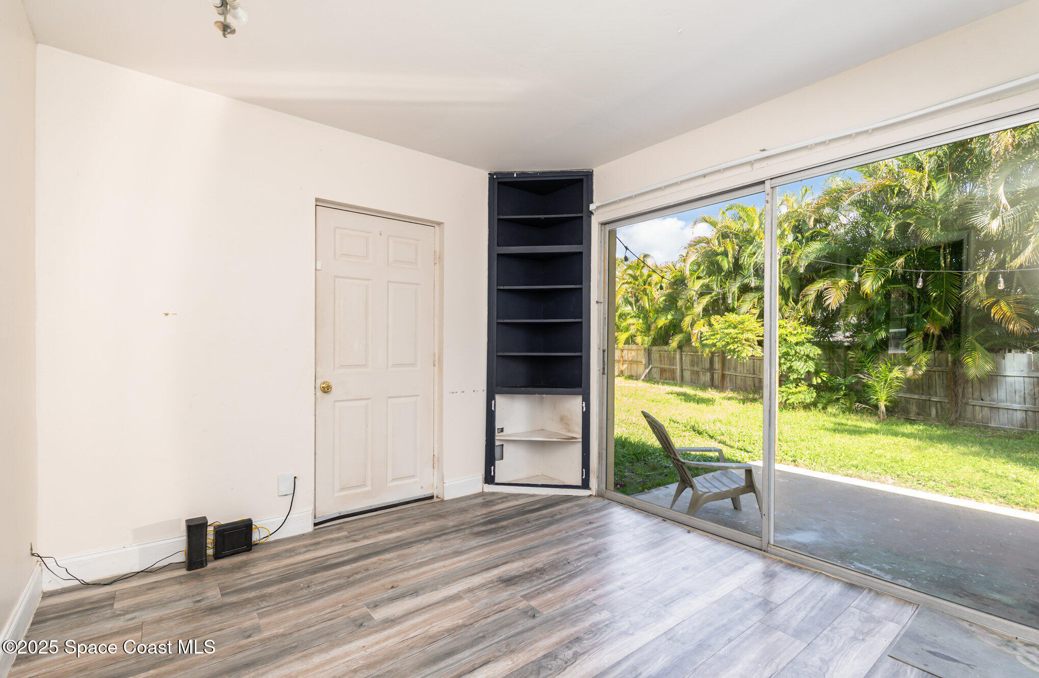 1137 Delmar Terrace Palm Bay, FL 32905 - Photo 17 of 35 a view of empty room with wooden floor and floor to ceiling window