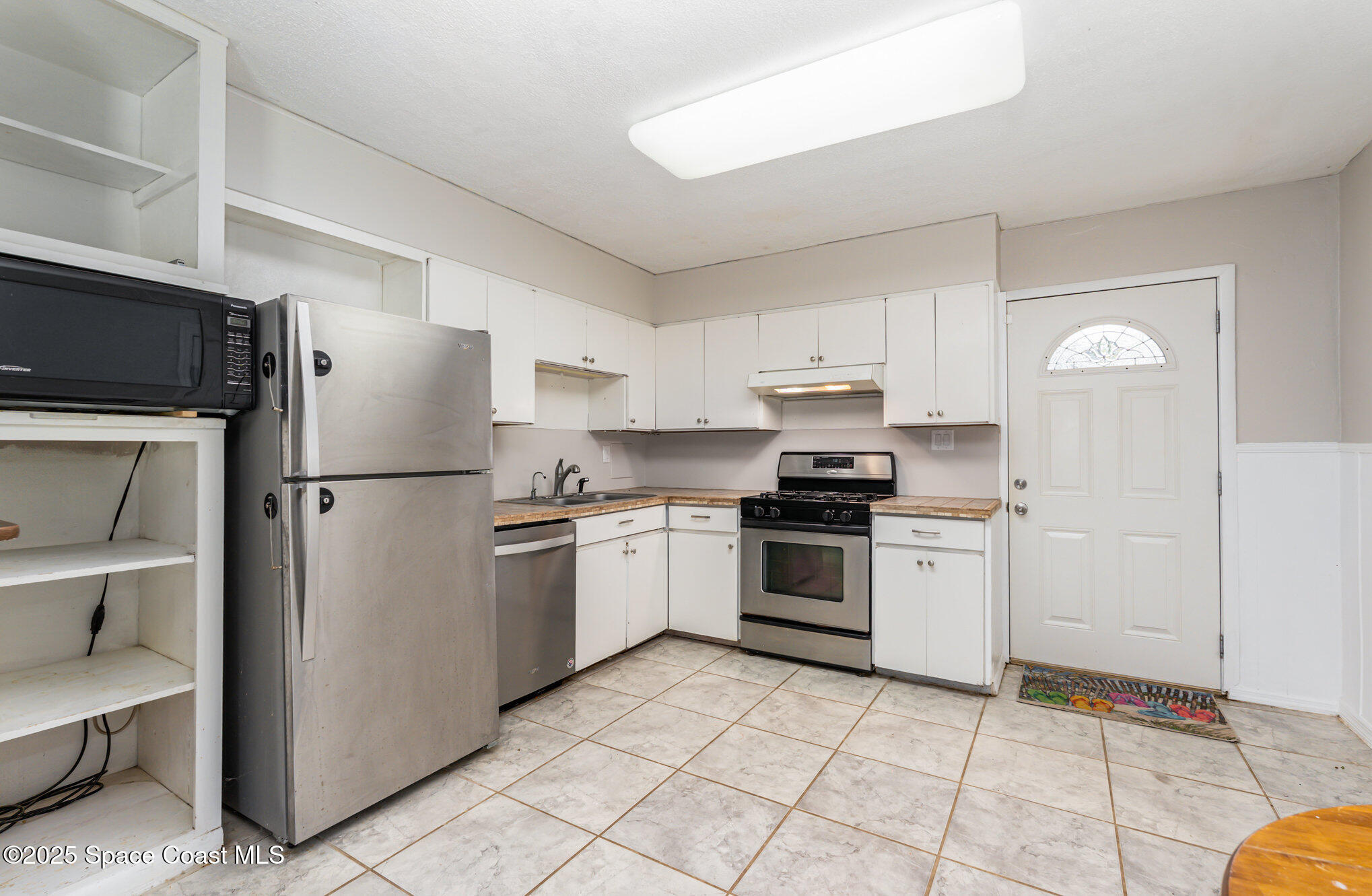 1137 Delmar Terrace Palm Bay, FL 32905 - Photo 6 of 35 a kitchen with a refrigerator sink and stainless steel appliances