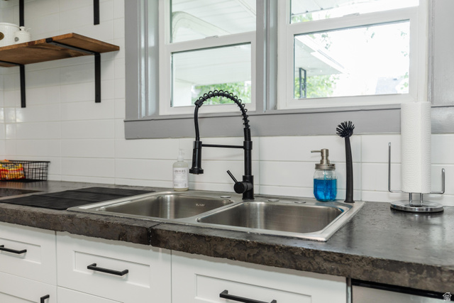 130 North 100 East Logan, UT 84321 - Photo 13 of 35 Dual basin stainless steel sink with a matte black pull-down faucet, set into a dark-toned countertop