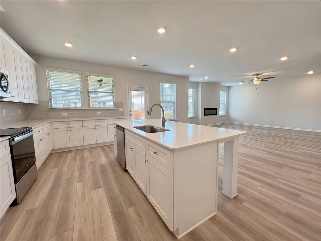 2790 Dolce Road Dacula, GA 30019 - Photo 16 of 66 a large white kitchen with wooden floor and stainless steel appliances