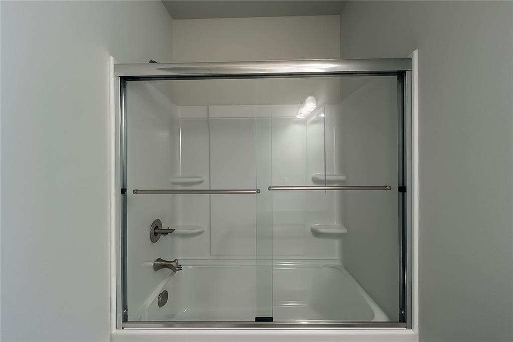 2790 Dolce Road Dacula, GA 30019 - Photo 26 of 66 a bathroom with a glass shower door