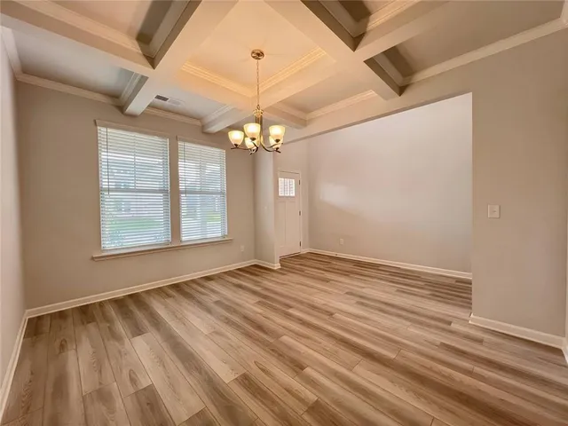 a large white kitchen with wooden floor and stainless steel appliances