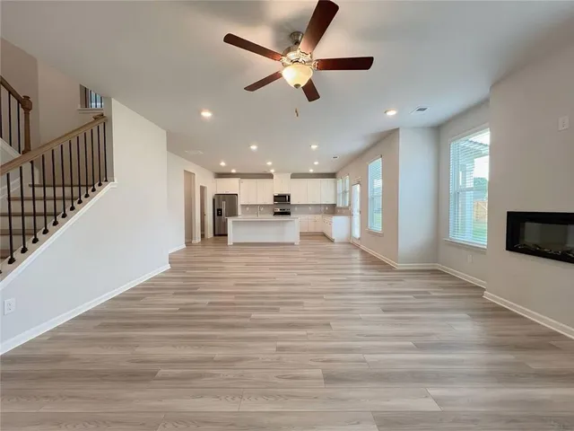 a view of kitchen with granite countertop white cabinets and stainless steel appliances