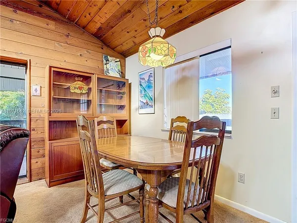 a view of a dining room with furniture a chandelier and wooden floor