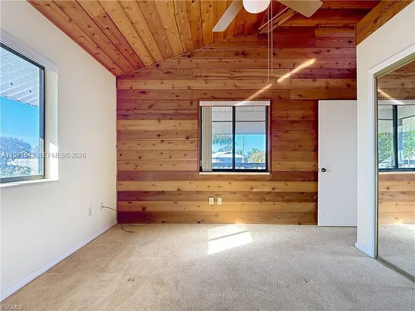a view of a rooftop deck with chairs and potted plants