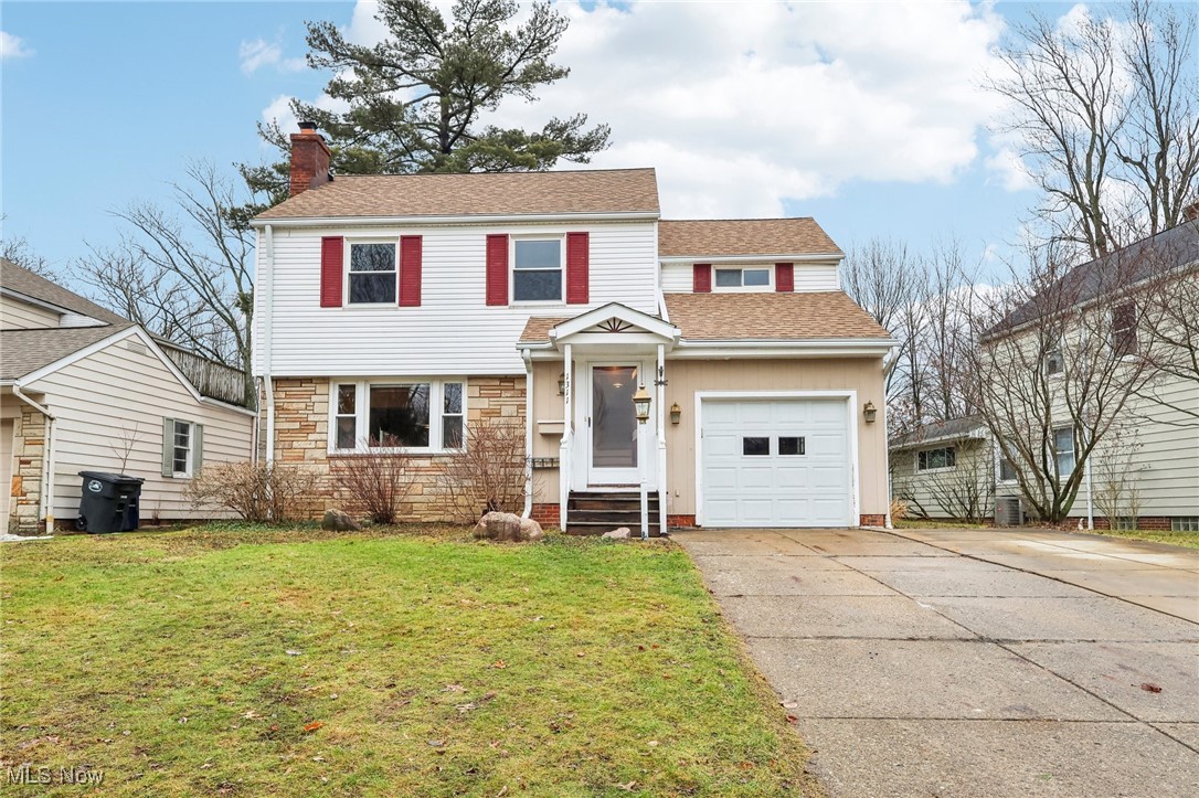 View of property with a garage and a front yard