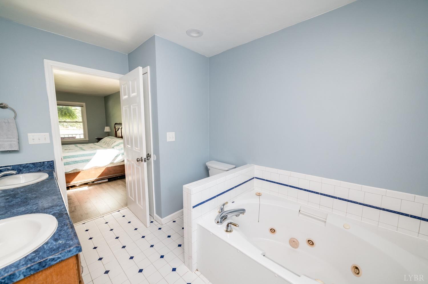 7996 Rocky Ford Road Moneta, VA 24121 - Photo 14 of 45 a bathroom with a bathtub and a view of living room