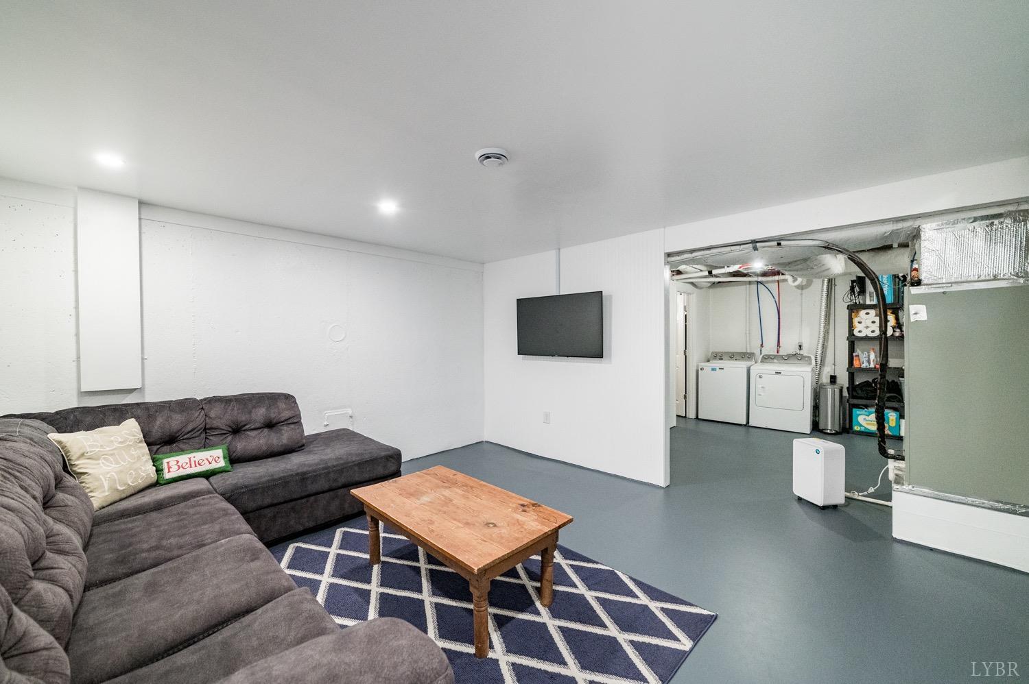 7996 Rocky Ford Road Moneta, VA 24121 - Photo 20 of 45 a living room with furniture a flat screen tv and a table