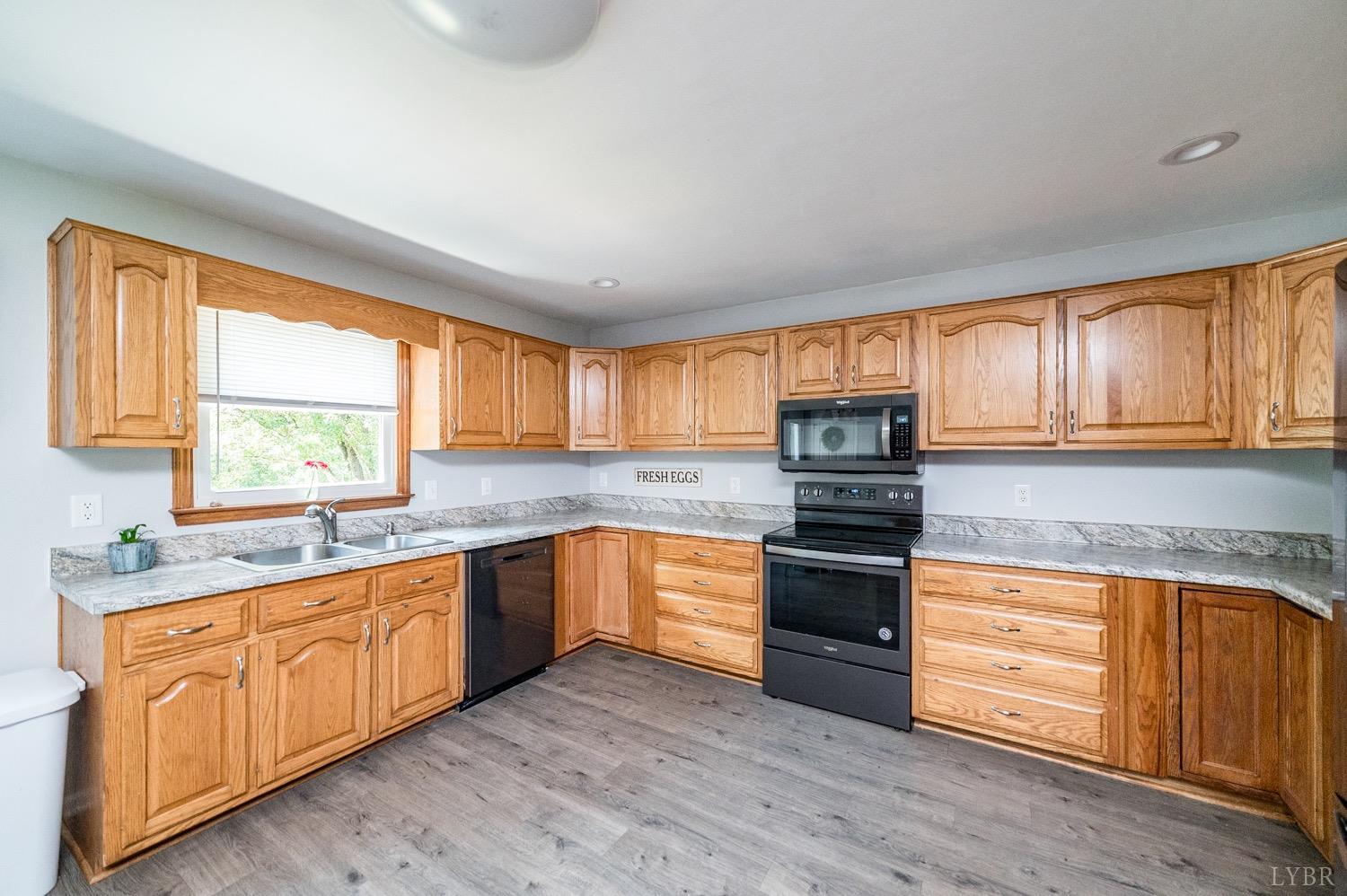 7996 Rocky Ford Road Moneta, VA 24121 - Photo 7 of 45 a kitchen with granite countertop wooden floors stainless steel appliances and window