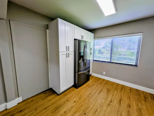 a view of empty room with wooden floor and window
