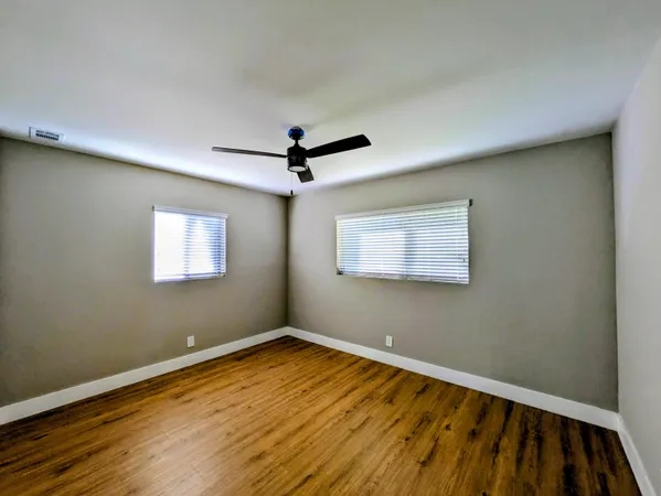 a view of empty room with wooden floor