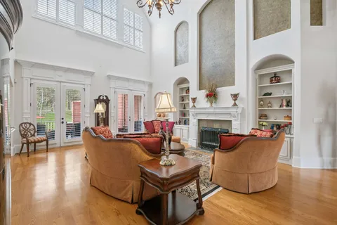 a living room with fireplace furniture and a chandelier