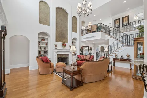 a kitchen with stainless steel appliances granite countertop a stove a sink dishwasher a refrigerator and white cabinets with wooden floor