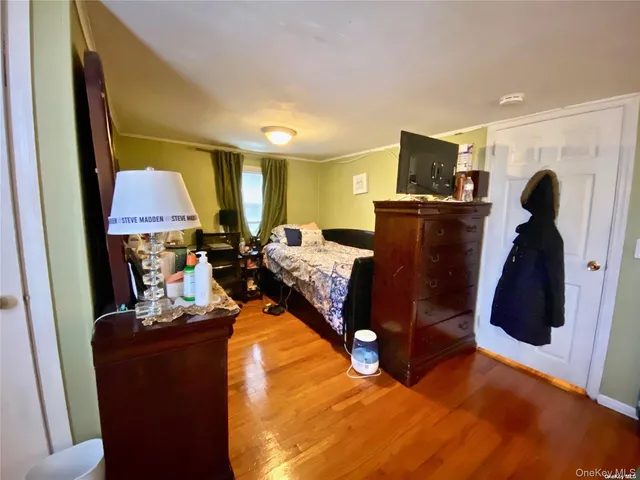 a bedroom with a bed a dresser and a flat screen tv