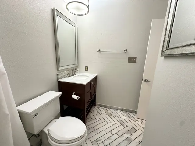 a bathroom with a toilet sink and mirror