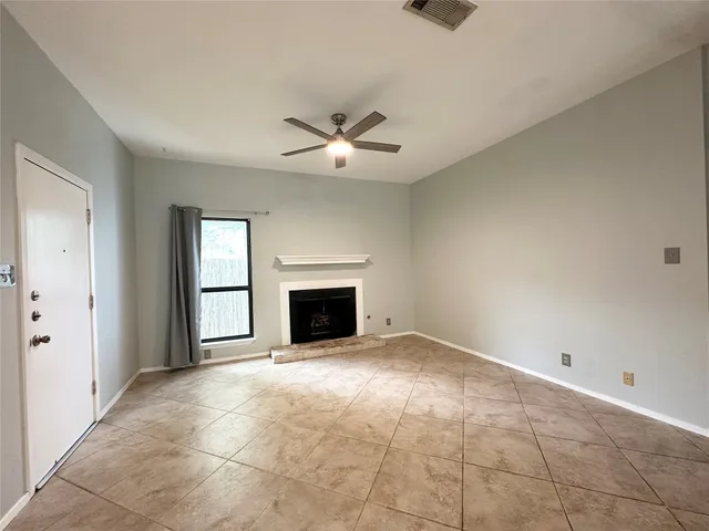 a view of an empty room with a fireplace and a window