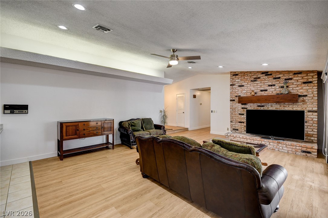 1401 Sharon Road Las Vegas, NV 89106 - Photo 30 of 73 Warm wood floors and a texture-rich brick fireplace accent wall anchor this open living area.