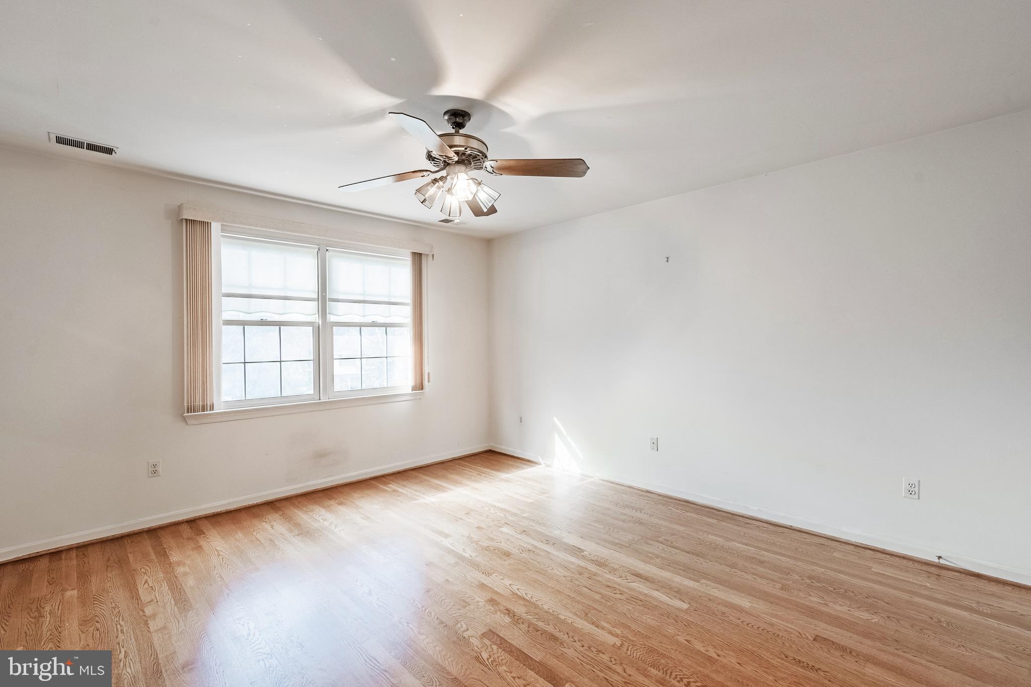8454 Toll House Road Annandale, VA 22003 - Photo 49 of 65 an empty room with wooden floor chandelier fan and windows
