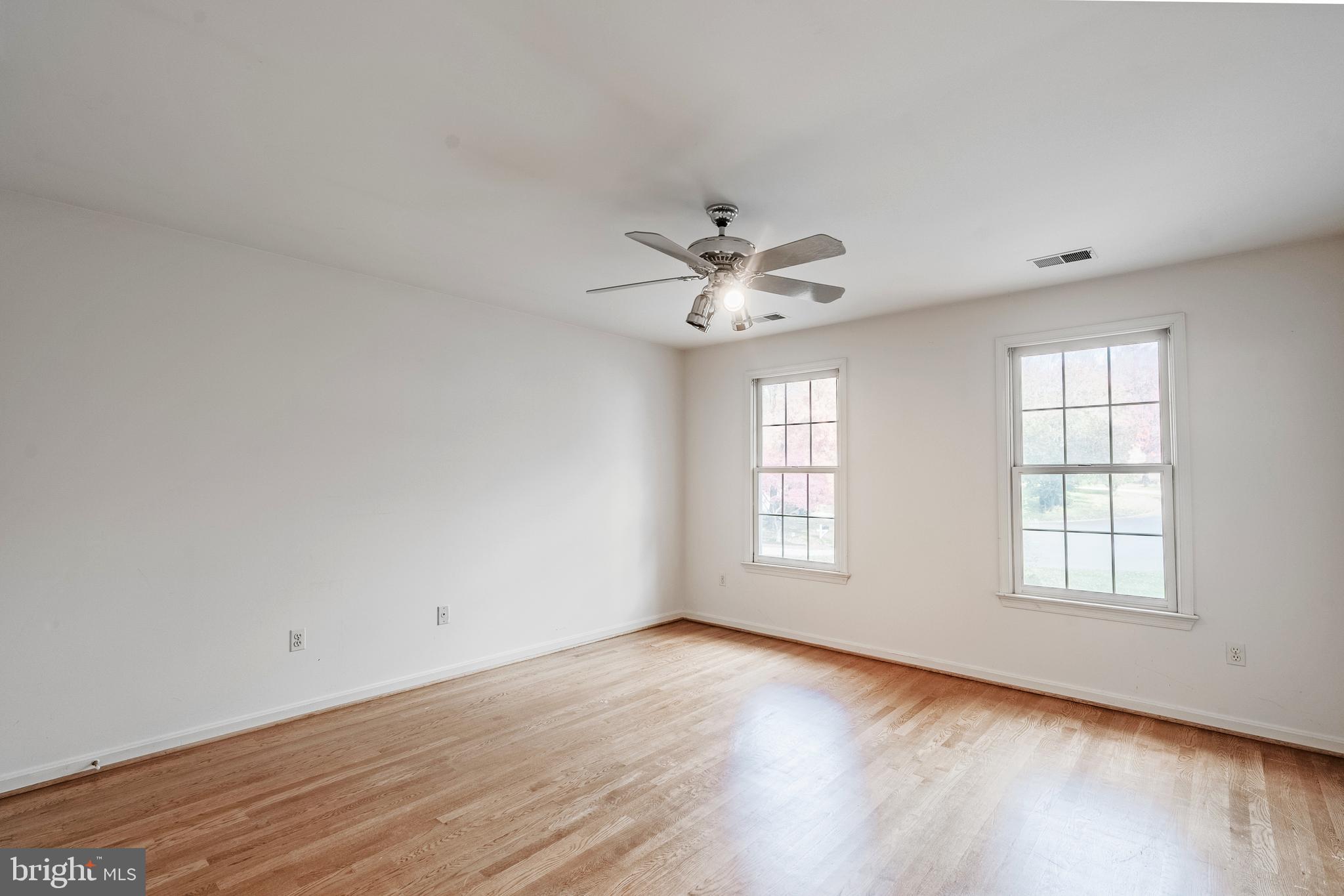 8454 Toll House Road Annandale, VA 22003 - Photo 51 of 65 an empty room with wooden floor chandelier fan and windows