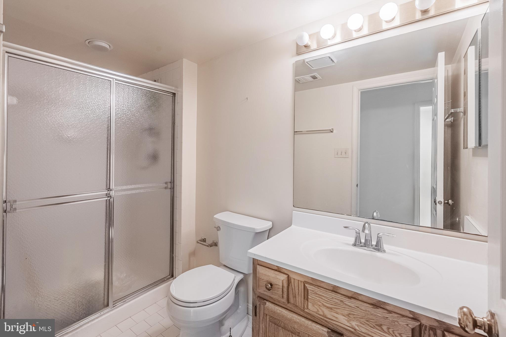 8454 Toll House Road Annandale, VA 22003 - Photo 63 of 65 a bathroom with a sink a toilet and a mirror