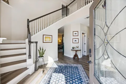 a view of a hallway with wooden floor and staircase