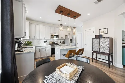 a kitchen with stainless steel appliances granite countertop a refrigerator sink and white cabinets