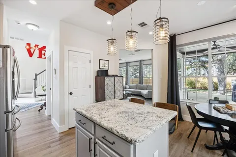 a view of a dining room and livingroom with furniture wooden floor a chandelier