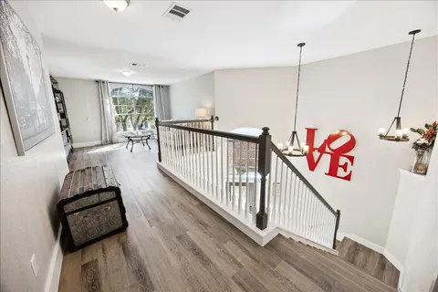 a view of hallway with furniture and wooden floor