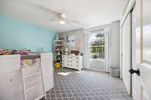 a view of a bedroom with baby crib and a window
