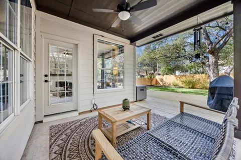 a living room with furniture a rug and a floor to ceiling window