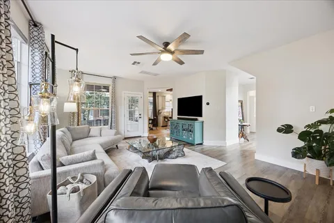 a living room with furniture a flat screen tv and a table
