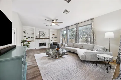 a living room with furniture a large window and a fireplace