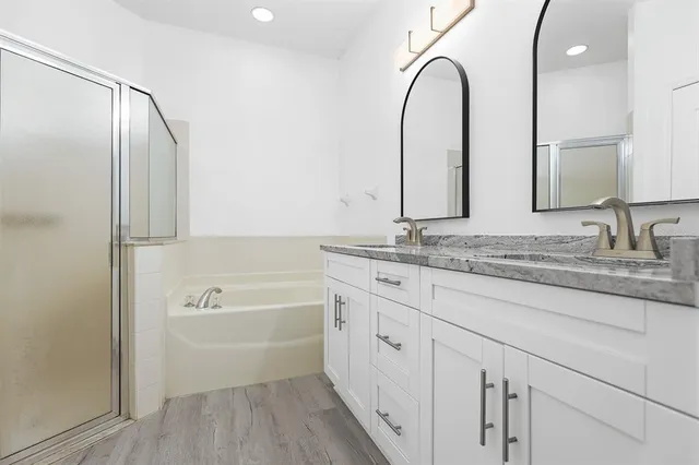 a spacious bathroom with a granite countertop sink a mirror and a shower