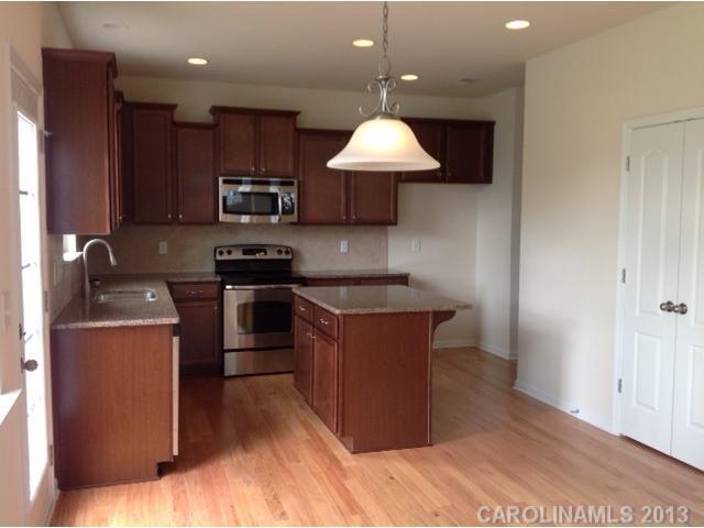 78047 Rillstone Drive, Unit 236 Lancaster, SC 29720 - Photo 6 of 16 a kitchen with kitchen island granite countertop a stove top oven a sink and a cabinets