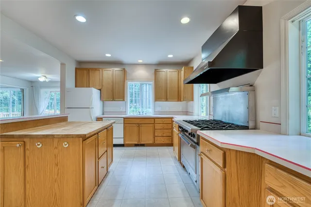a kitchen with stainless steel appliances granite countertop a stove a sink and a refrigerator