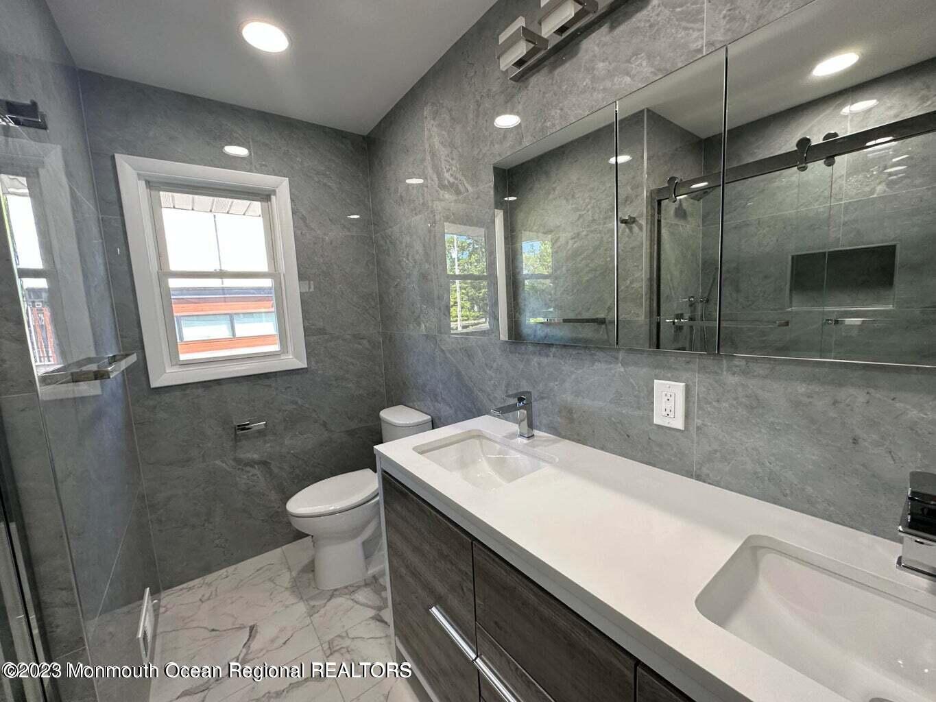 254 Garfield Avenue Oakhurst, NJ 07755 - Photo 15 of 26 a bathroom with a sink a toilet a mirror and window