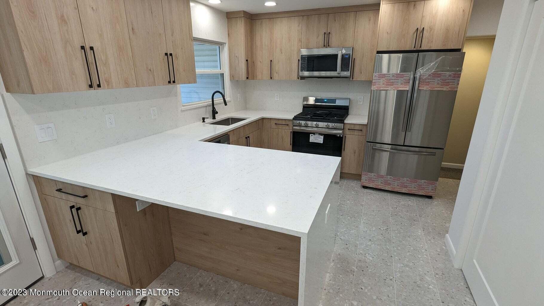 254 Garfield Avenue Oakhurst, NJ 07755 - Photo 4 of 26 a kitchen with stainless steel appliances a refrigerator a sink a stove a microwave and cabinets