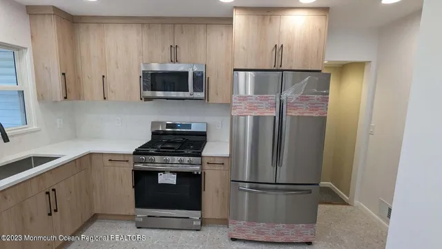 a kitchen with stainless steel appliances granite countertop a refrigerator stove and microwave