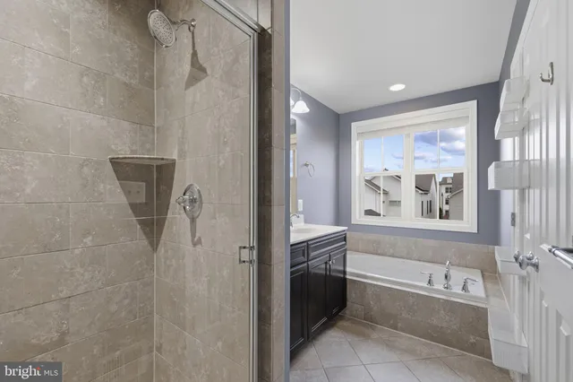a bathroom with a tub a sink double vanity and windows