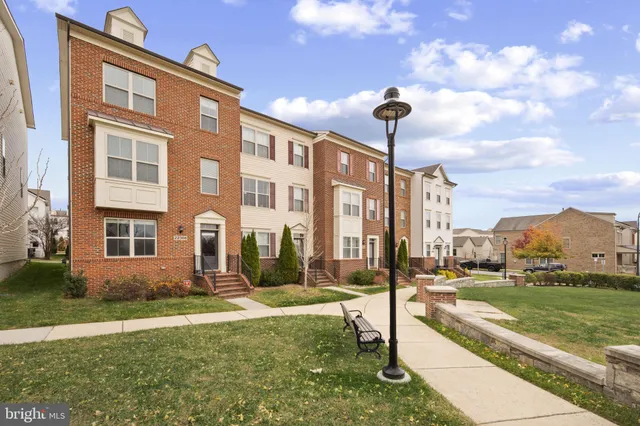 a front view of a building with a garden and plants