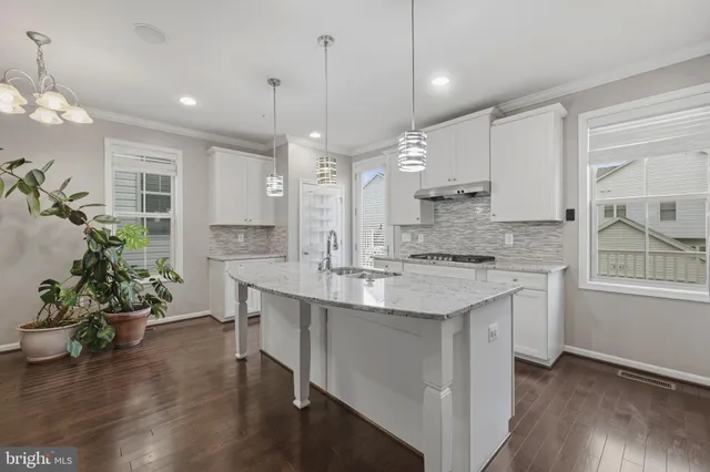 a large kitchen with granite countertop a sink a counter space and stainless steel appliances