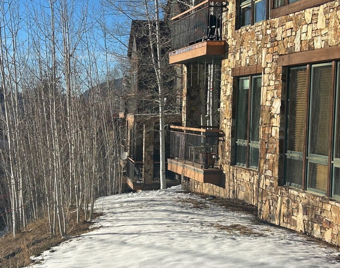 404 Adams Ranch Road, Unit 1201 Mountain Village, CO 81435 - Photo 9 of 47 a view of a house with a wooden fence
