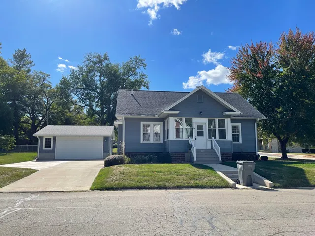 a front view of a house with a garden and plants