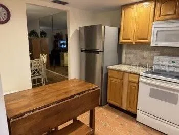 a kitchen with stainless steel appliances granite countertop a refrigerator and a stove top oven