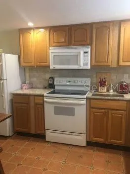 a kitchen with a stove sink and cabinets
