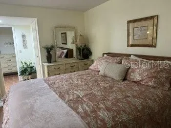 a bedroom with a bed and a mirror on dresser