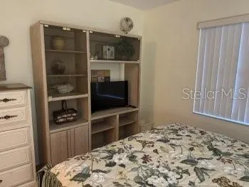 a bedroom with a bed and a television